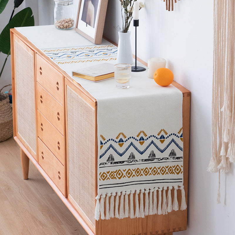 Woven table runner with fringes and ethnic chevron pattern
