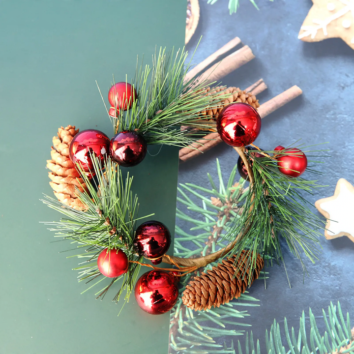 Christmas candle wreath with berries and pine cones