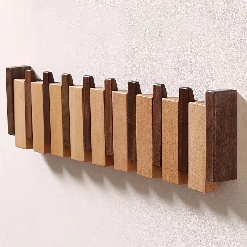 Wooden coat rack in piano design with foldable hooks | Bowlift