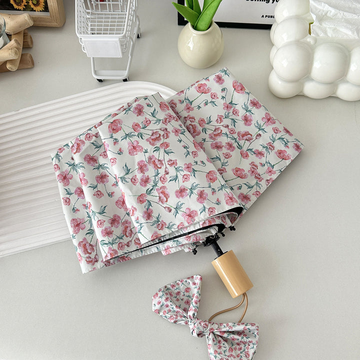 Women's folding umbrella with floral design and practical storage system Bowlift