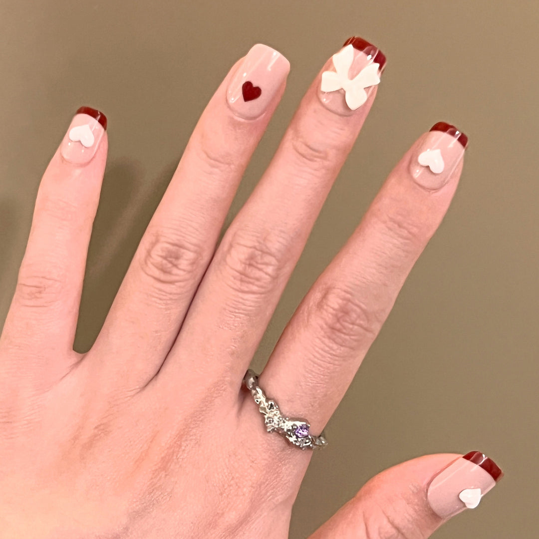 Artful nail art with heart and bow motifs Bowlift