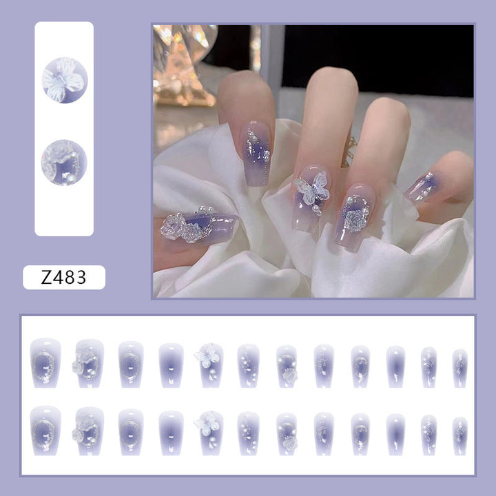 Artistic acrylic nails with butterfly design and glitter accents Bowlift