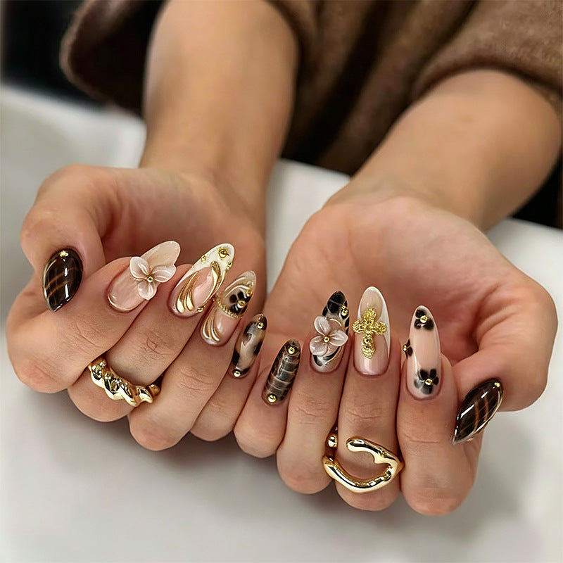 Artificial nails set with elegant gold accents and floral embellishments Bowlift