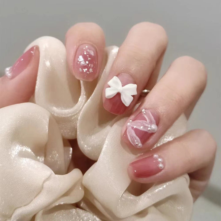 Glamorous nail art with pearl and bow accents Bowlift