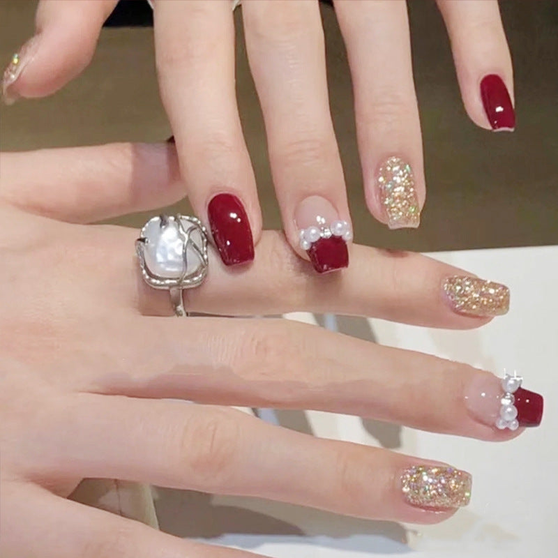 Glamorous artificial nails with glitter and pearl decorations Bowlift