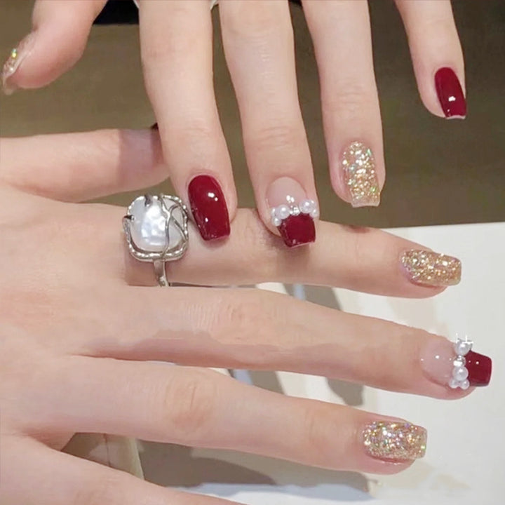Glamorous artificial nails with glitter and pearl decorations Bowlift