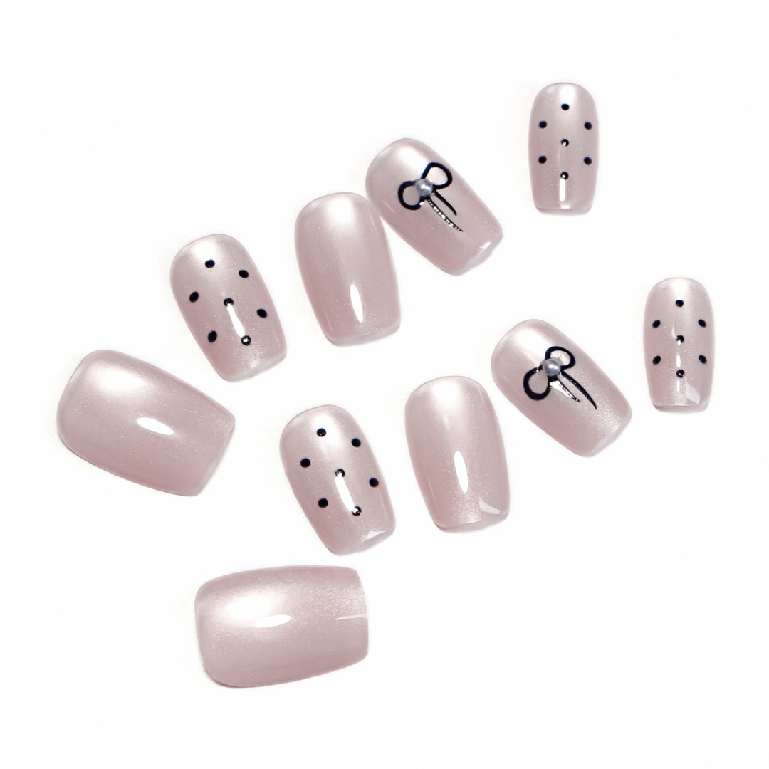 Artificial nail extensions with decorative bows and dots Bowlift