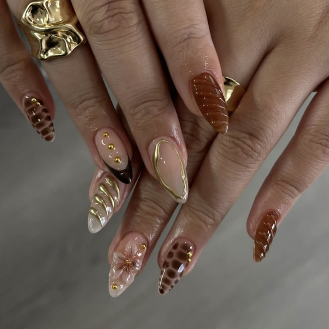 Artificial nails in modern stiletto design with golden accents Bowlift