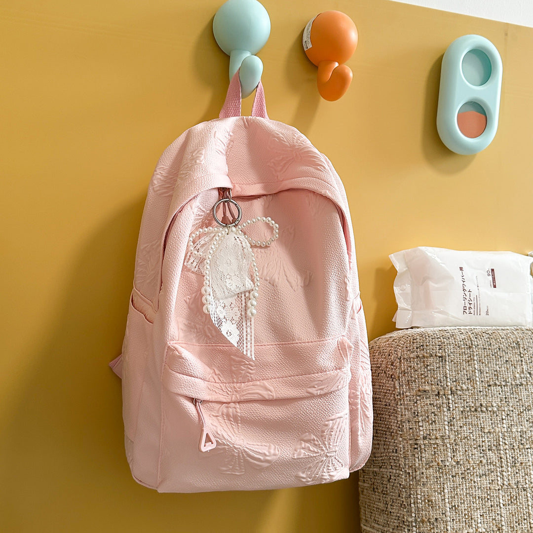 Elegant Textured Backpack with Decorative Charm