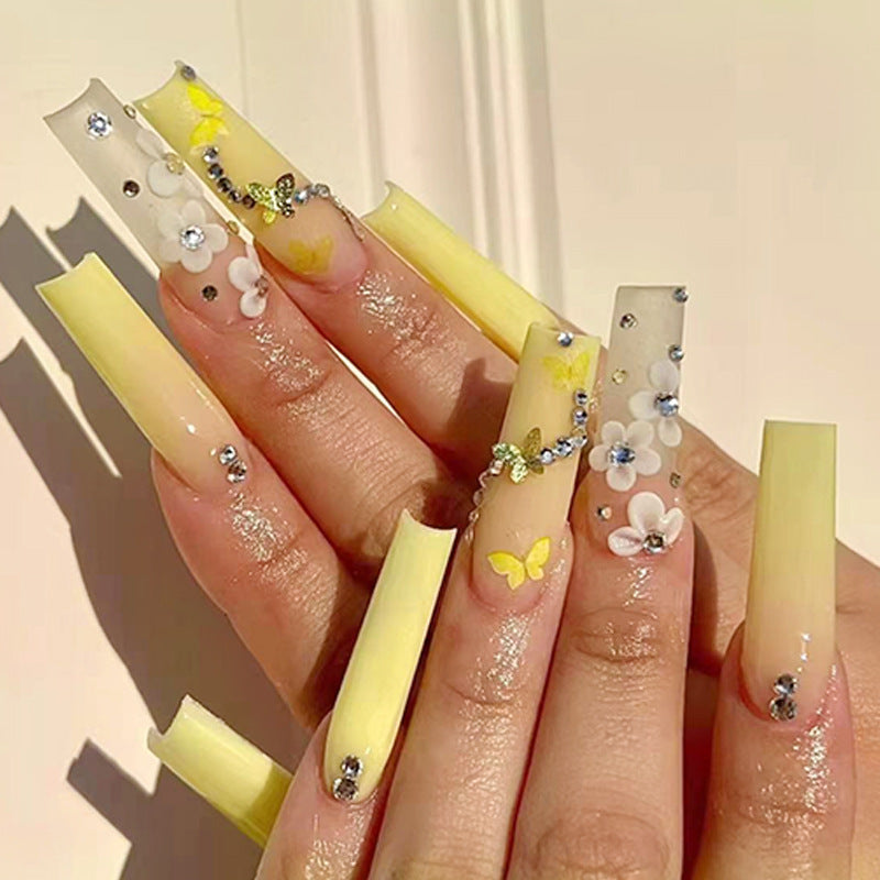 Artificial nail extensions with floral accents and rhinestones Bowlift