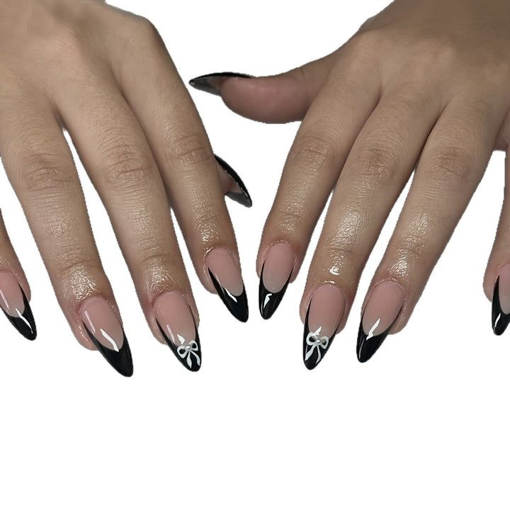 Acrylic nail set with elegant black and white design and cute bow accents Bowlift