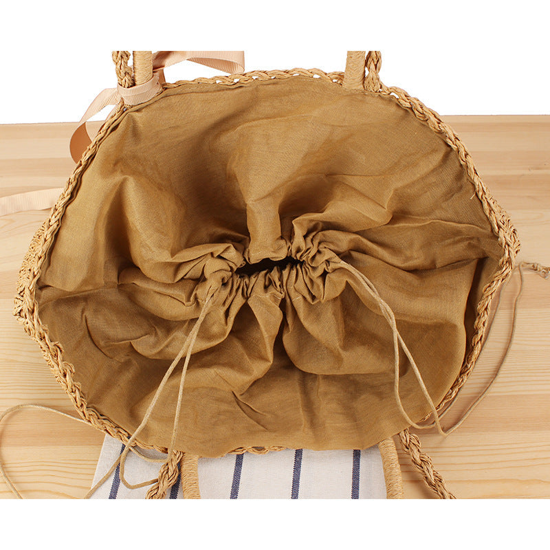 Beach bag made of natural raffia with playful design and elegant bow decoration Bowlift