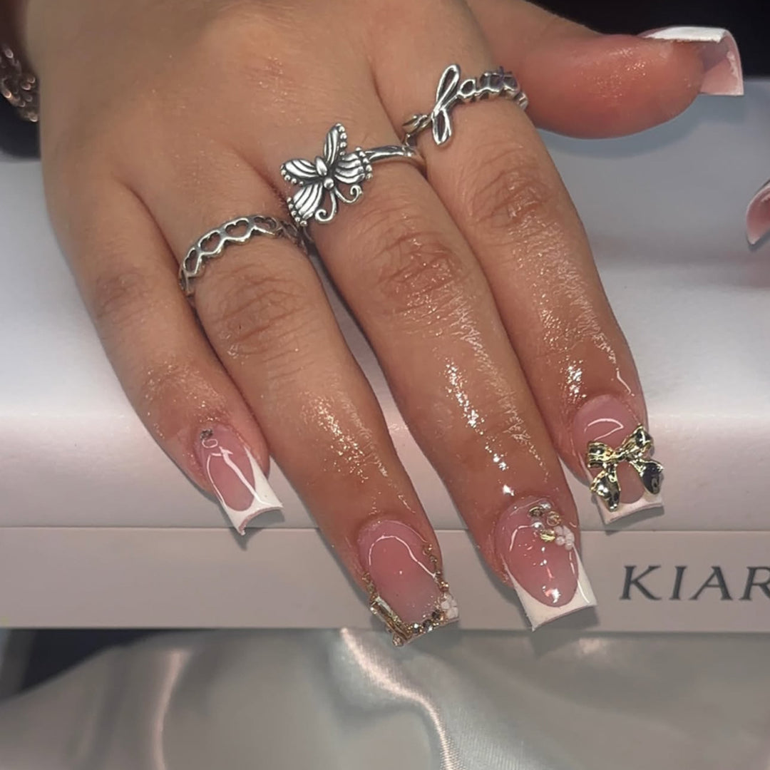 Elegant Nail Extensions with French Tips and Decorative Accents Bowlift