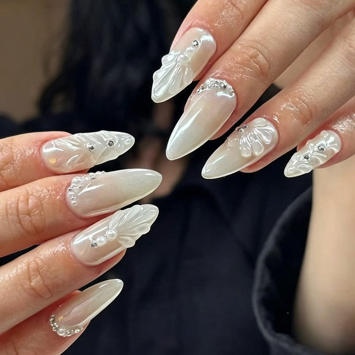 Elegant Stiletto Nail Enhancements with Decorative Pearls Bowlift