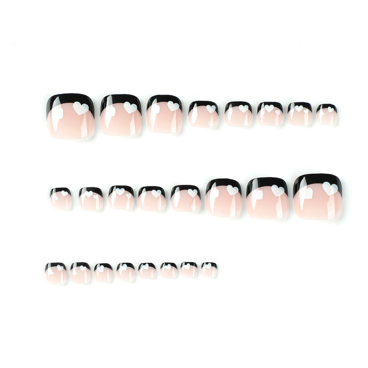 Artistic toenail design with heart motifs and modern black-and-white design Bowlift