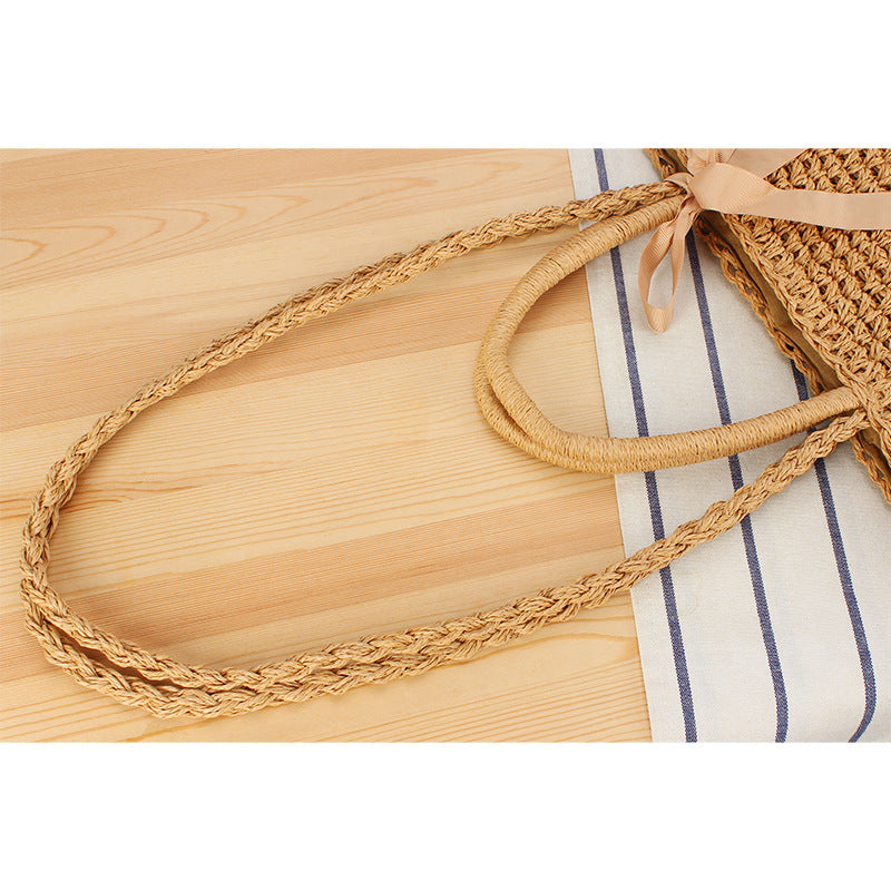 Beach bag made of natural raffia with playful design and elegant bow decoration Bowlift