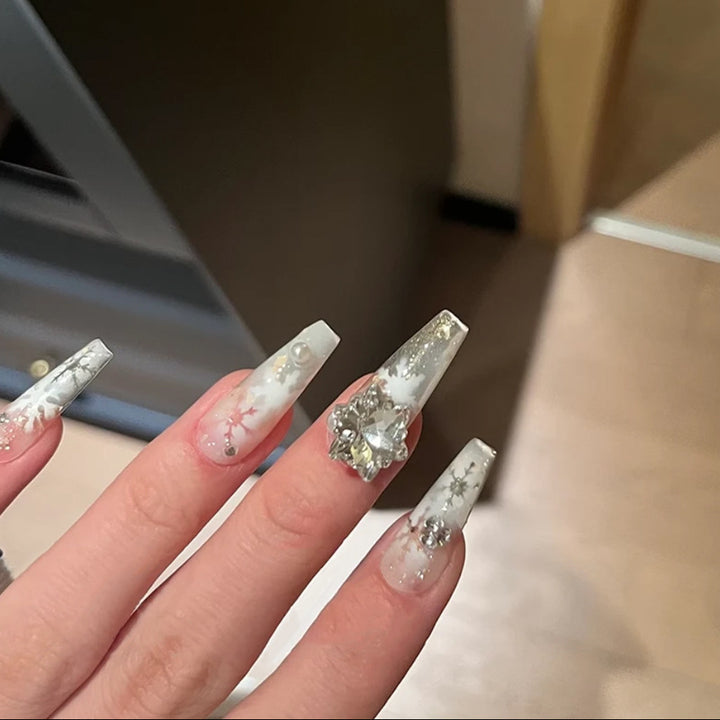 Artificial nail set with frosty snowflake design and sparkling 3D applications Bowlift