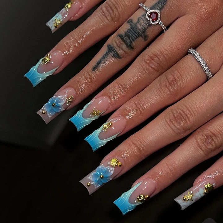 Artful nail art with floral accents and glitter effects Bowlift