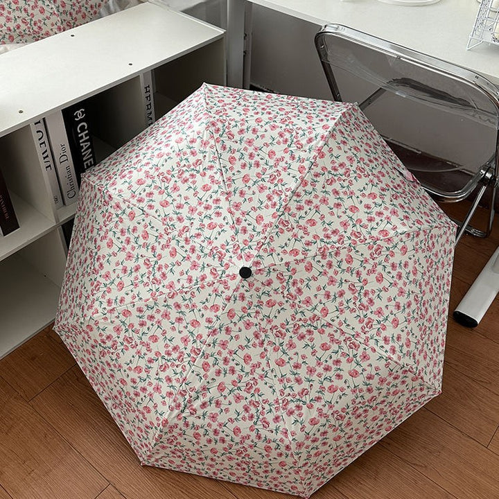 Women's folding umbrella with floral design and practical storage system Bowlift