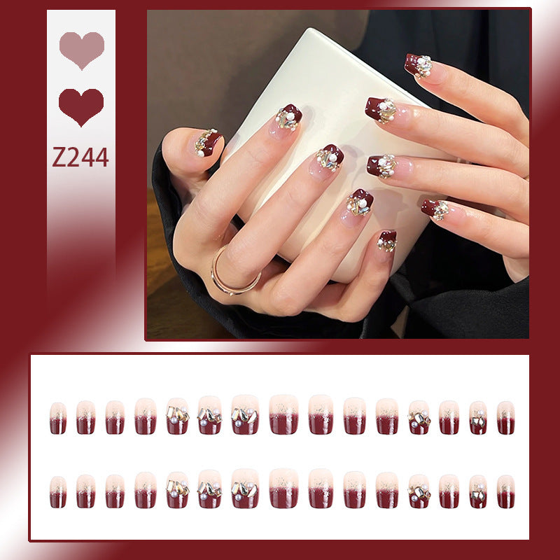 Glamorous artificial nails with decorative pearl and glitter embellishments Bowlift