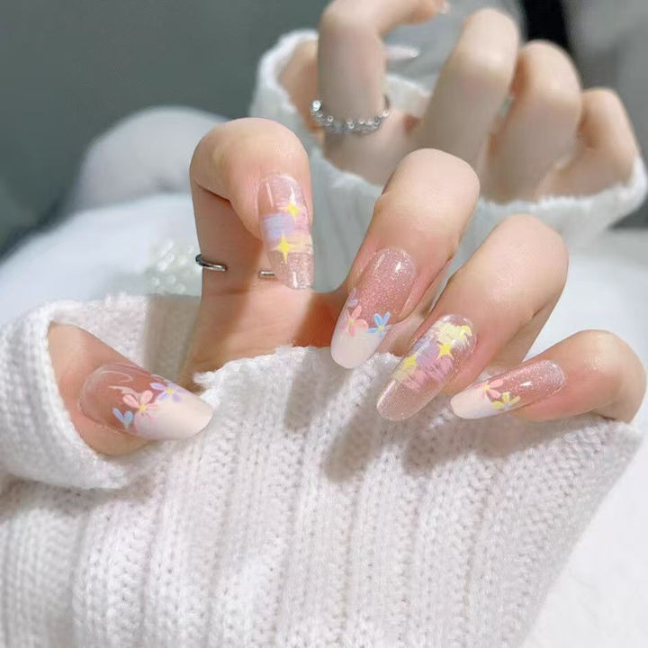 Artificial nails with delicate floral accents and glitter effects Bowlift