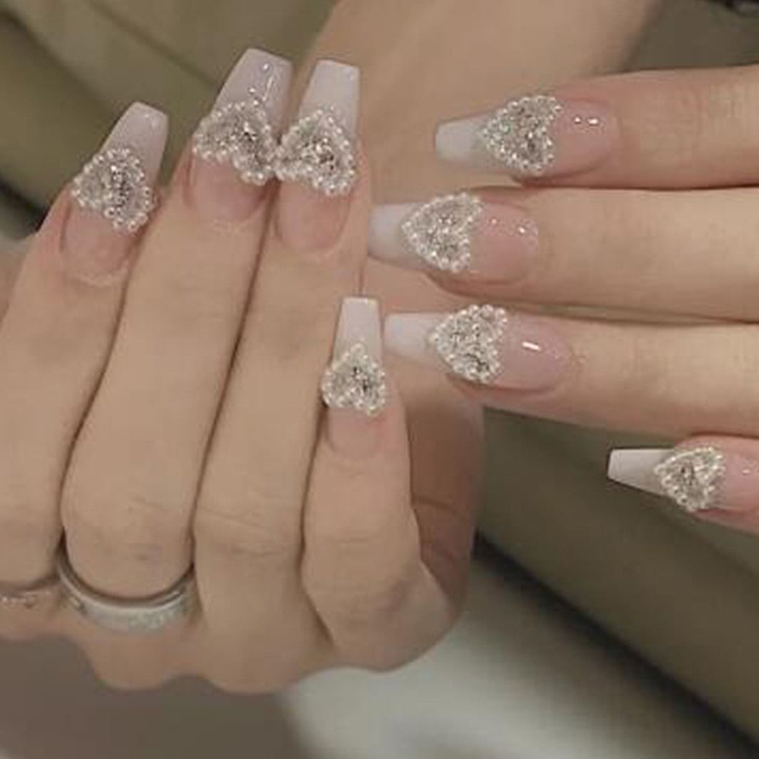 Artificial nail art with heart and rhinestone decorations Bowlift