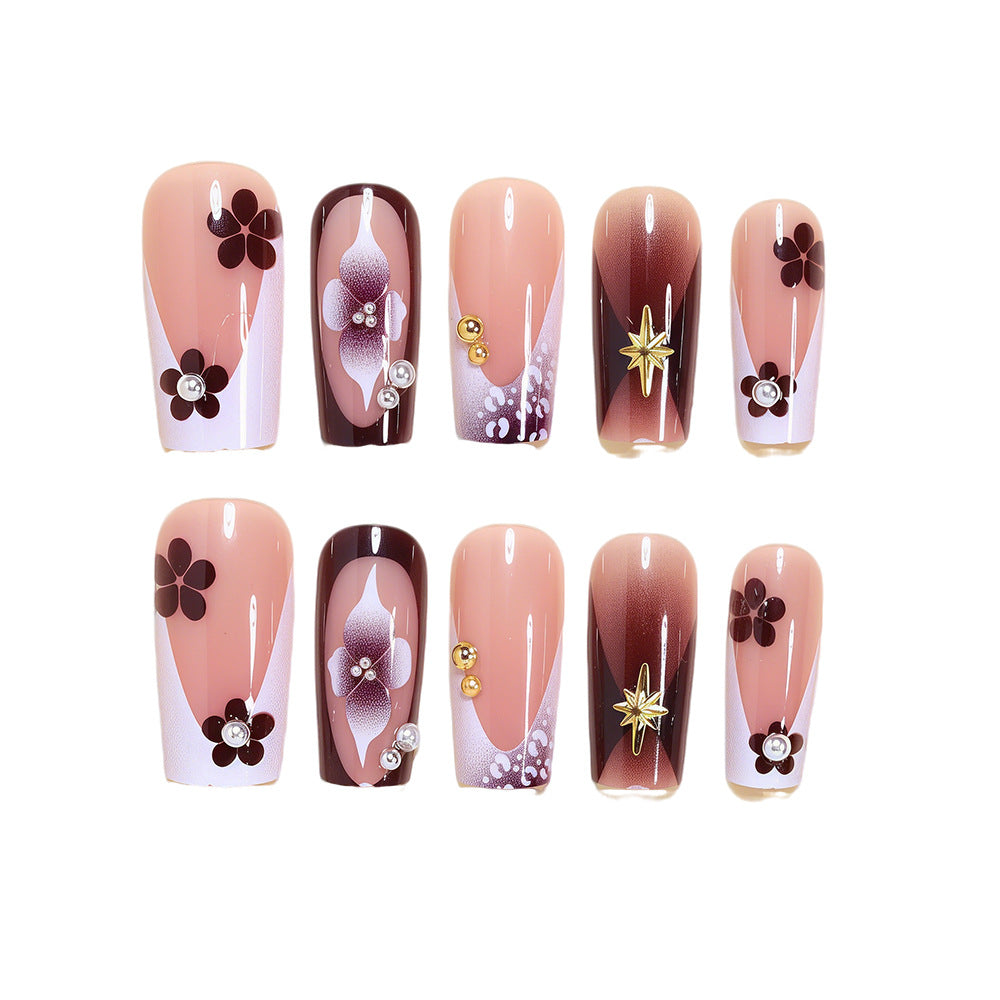 Artistic Acrylic Nail Design Set with Floral and Gold Accents Bowlift