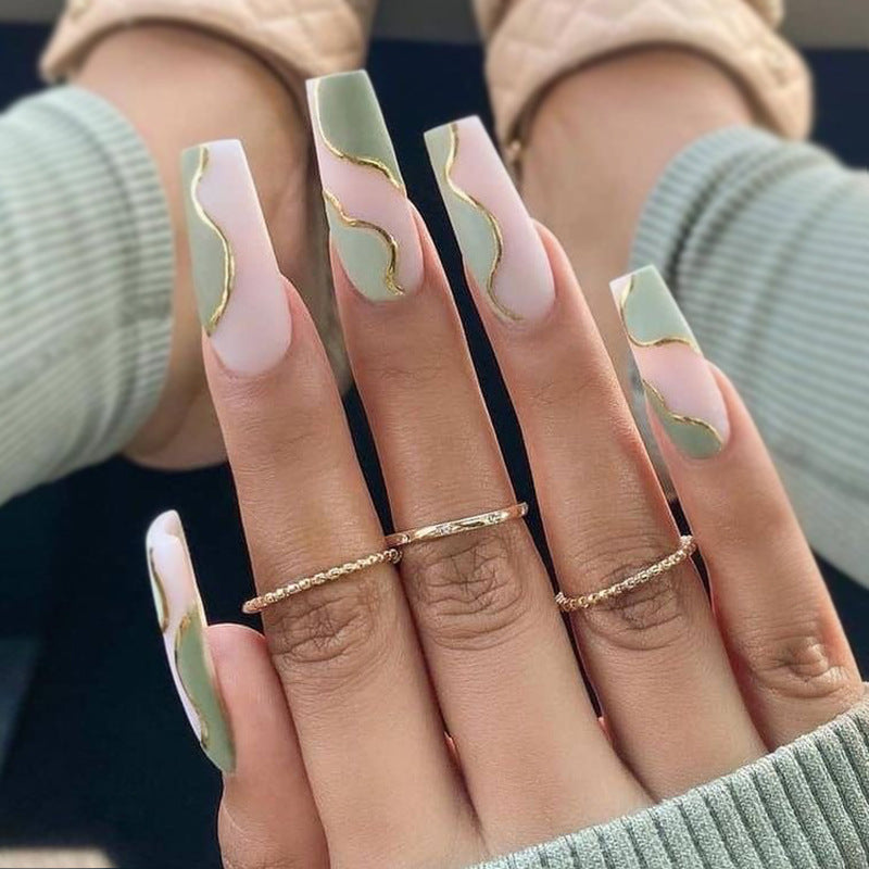 Artful Gel Nails with Elegant Wave Design and Gold Accents Bowlift