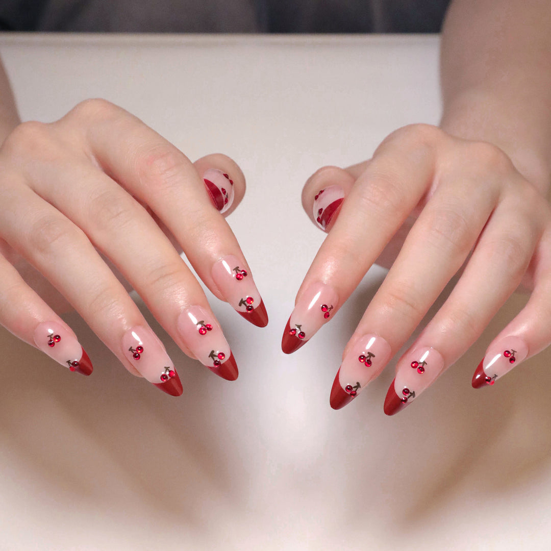 Artful stiletto nails with cherry motifs and glitter accents Bowlift