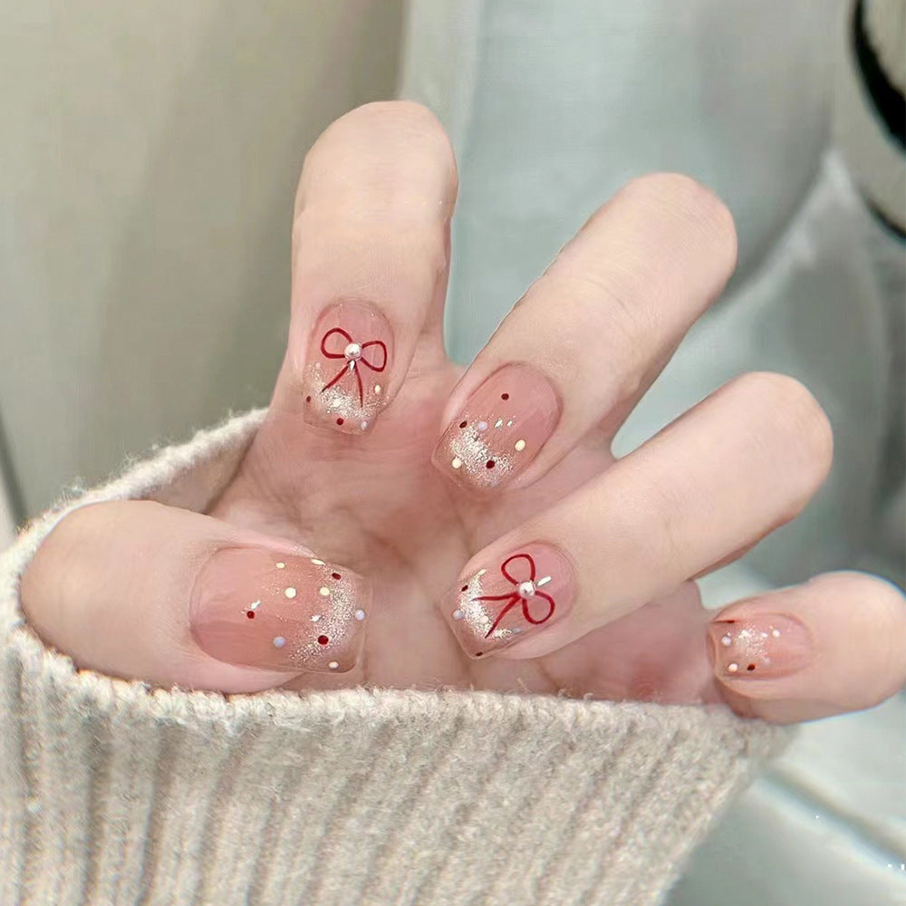 Artificial nail art with elegant bows and glitter accents Bowlift