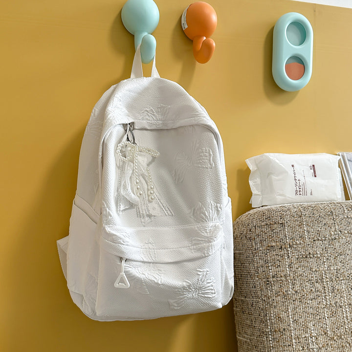 Elegant Textured Backpack with Decorative Charm