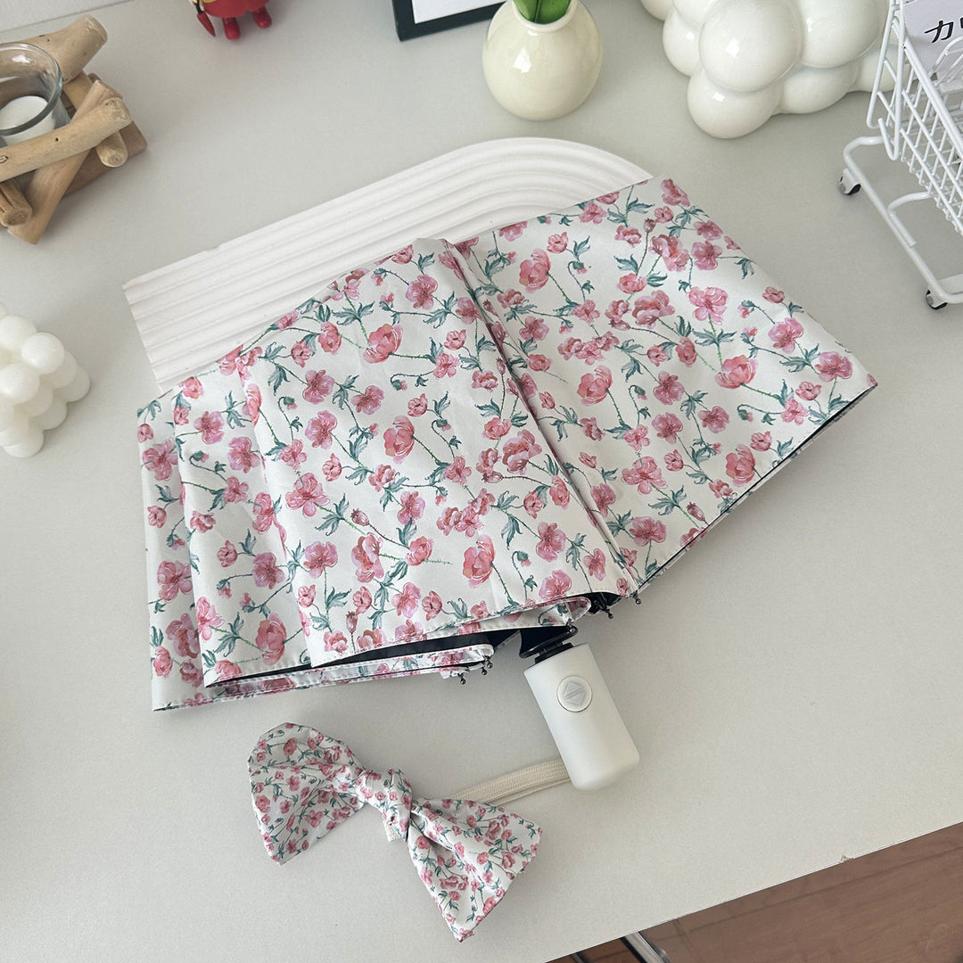 Women's folding umbrella with floral design and practical storage system Bowlift