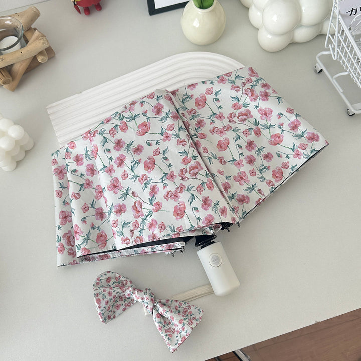 Women's folding umbrella with floral design and practical storage system Bowlift