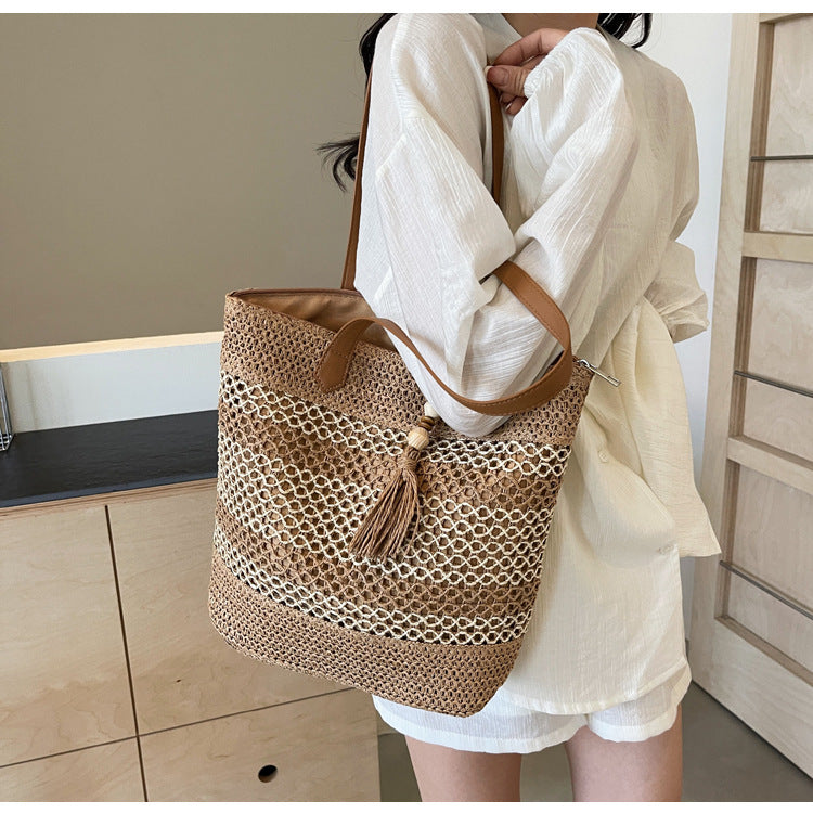 Handbag made of woven natural material with playful tassel detail Bowlift