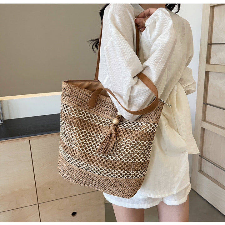 Handbag made of woven natural material with playful tassel detail Bowlift