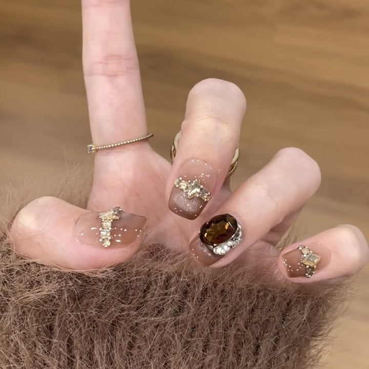 Artificial nail art with glitter and jewelry embellishments Bowlift