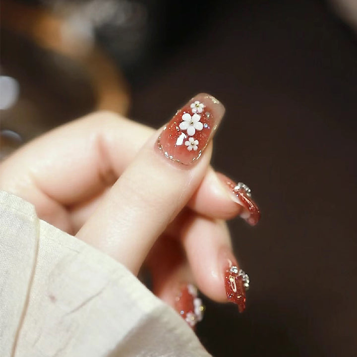 Artistic Press-On Nail Art with Floral and Glitter Accents Bowlift