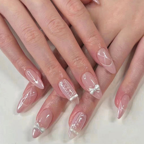 Artistic stiletto nails with elegant pearl and bow accents Bowlift