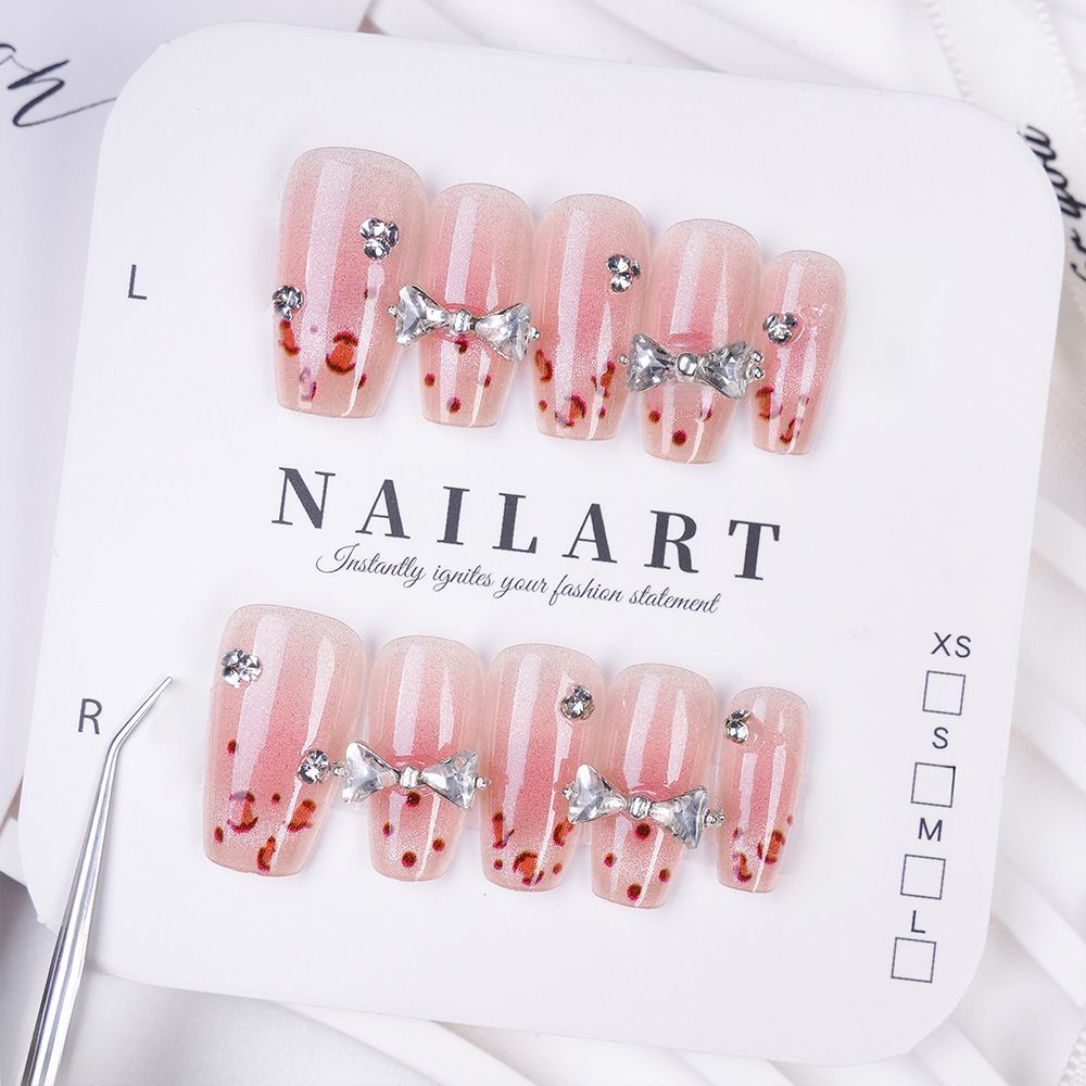 Art nails with delicate rhinestone and bow accents Bowlift