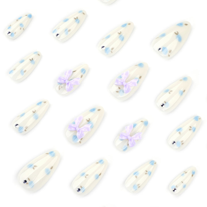 Artful stiletto nails with delicate flower patterns and glitter accents Bowlift