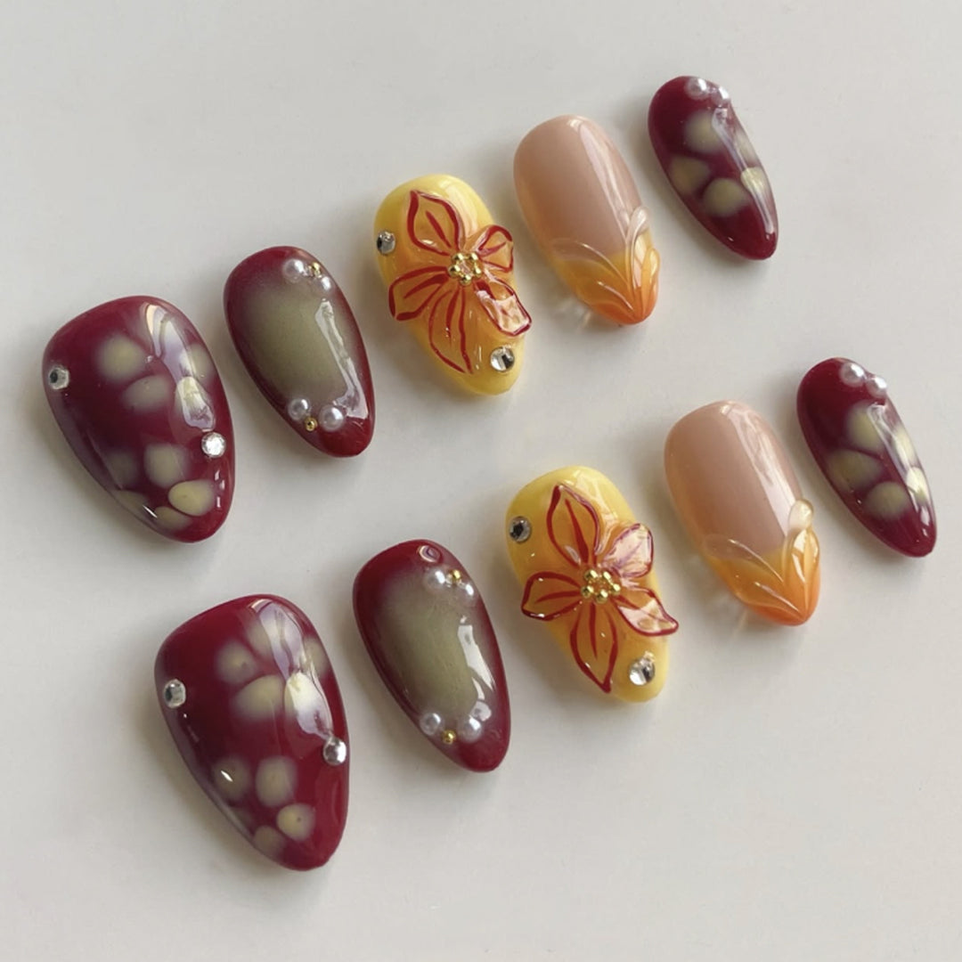 Artificial nail extensions with floral design and rhinestone embellishments Bowlift