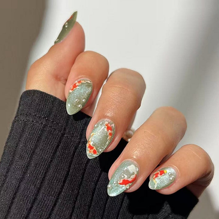Artificial nail set with filigree koi fish designs and glitter accents Bowlift