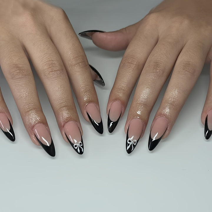 Acrylic nail set with elegant black and white design and cute bow accents Bowlift