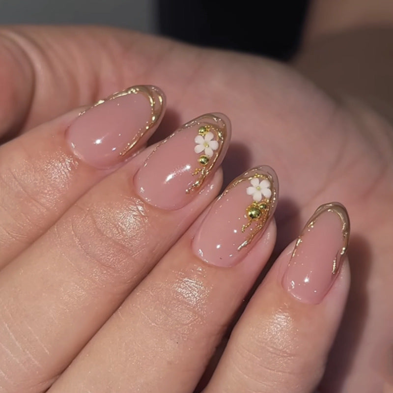 Artful nail design with golden accents and floral details Bowlift