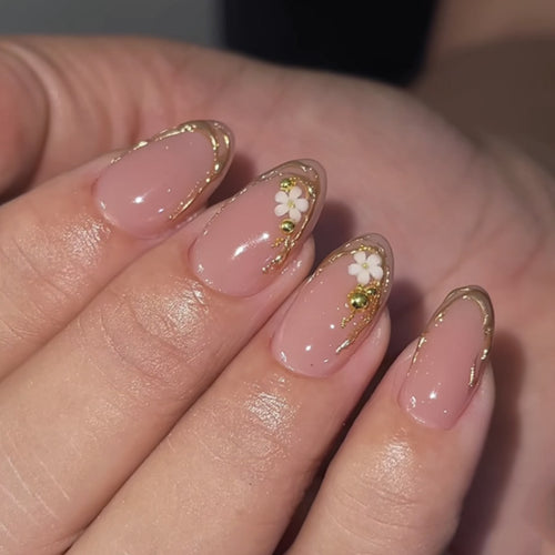 Artful nail design with golden accents and floral details Bowlift