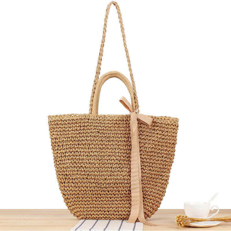 Beach bag made of natural raffia with playful design and elegant bow decoration Bowlift