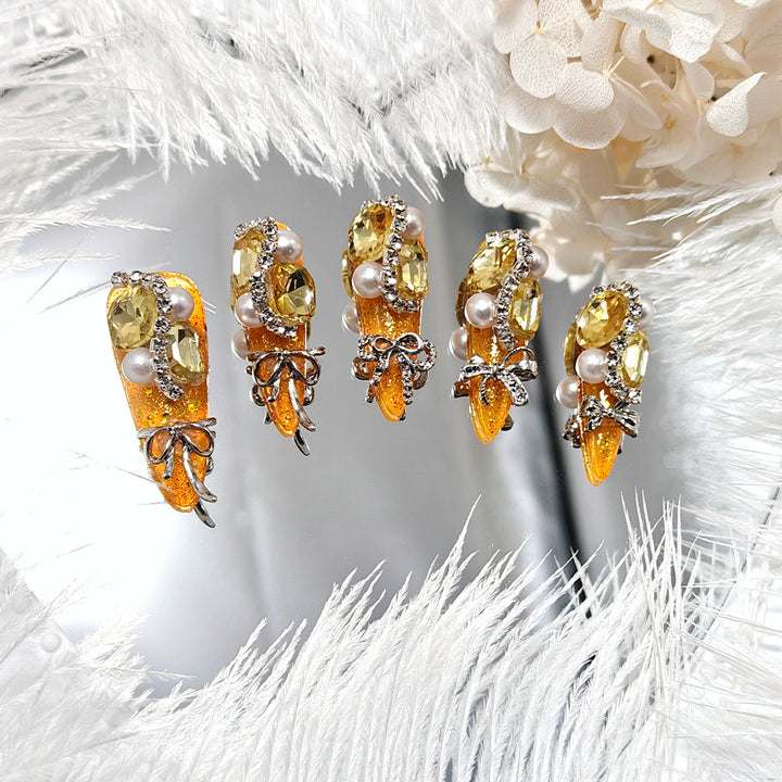 Glamorous artificial nails with rhinestones and pearl embellishments Bowlift