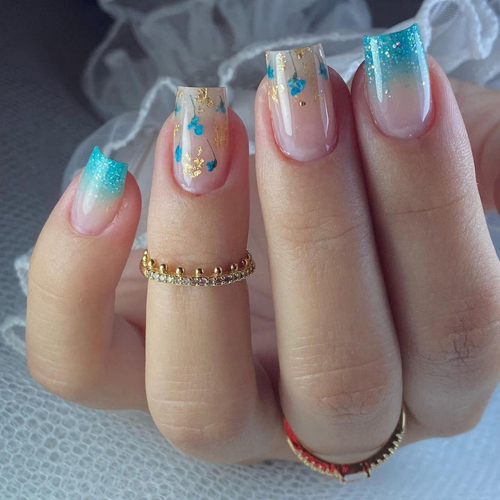 Artful acrylic nails with floral design and glitter effects Bowlift