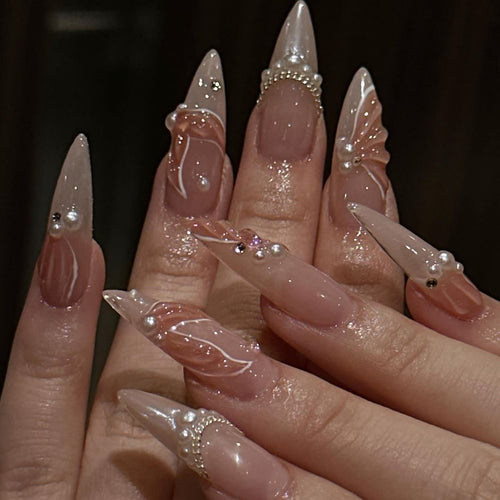 Artistic stiletto nails with pearl and flower embellishments Bowlift
