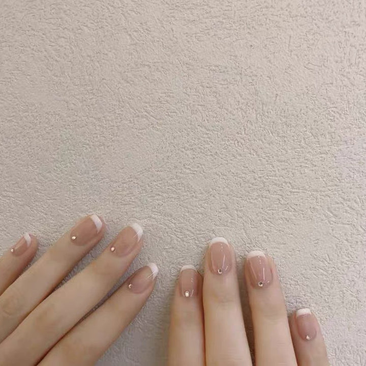 Artificial nails with elegant French tip and rhinestone accents Bowlift